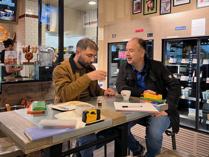 Kasim et Mustafa discutent en prenant un café